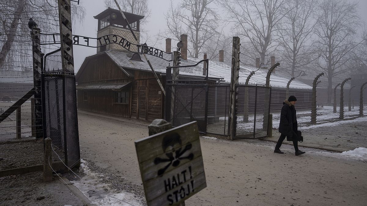 A man walks past the ‘Arbeit Macht Frei’ (Work Sets You Free) gate at the Memorial and Museum Auschwitz-Birkenau, 23 January, 2025