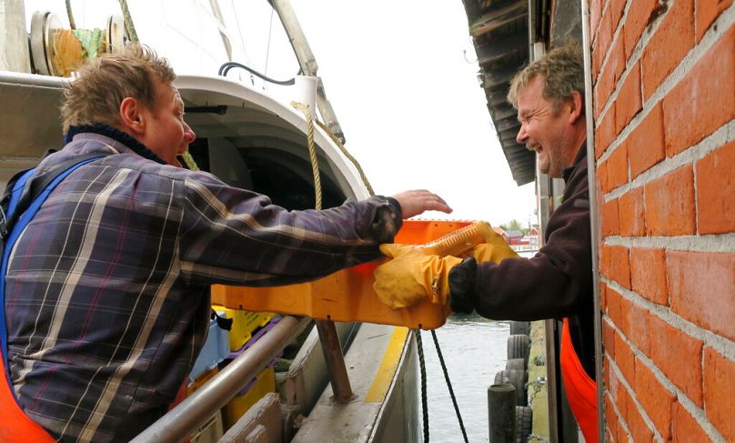 Ulrik Koelle Hansen, à gauche, remet une caisse de plie à un employé d'entrepôt à Bagenkop, Danemark, octobre 2016.