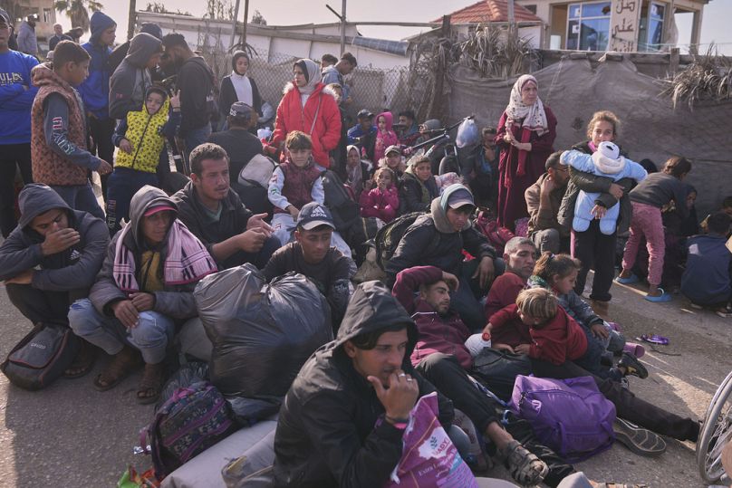 Les Palestiniens attendent à côté de leurs effets personnels dans le centre de Gaza, le samedi 25 janvier 2025, alors que l'armée israélienne avertit les Palestiniens de ne pas retourner dans le nord de Gaza