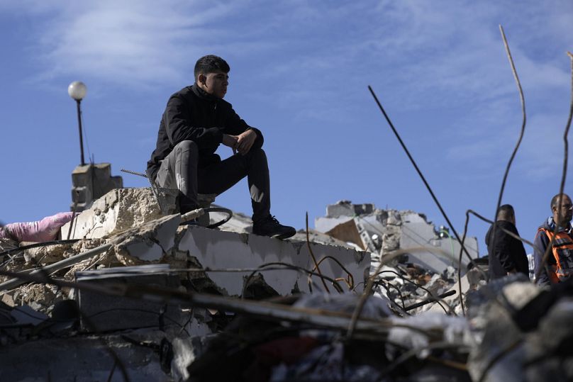 Un Palestinien est assis sur les décombres sur le site où les forces israéliennes ont tué deux militants palestiniens qui ont mené une attaque mortelle sur un bus en Cisjordanie plus tôt ce mois-ci