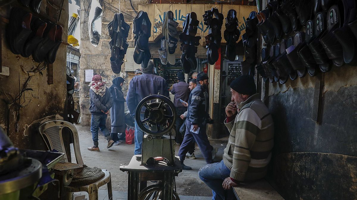 A shop owner sits inside his store in the old city market in Damascus, 9 January, 2025