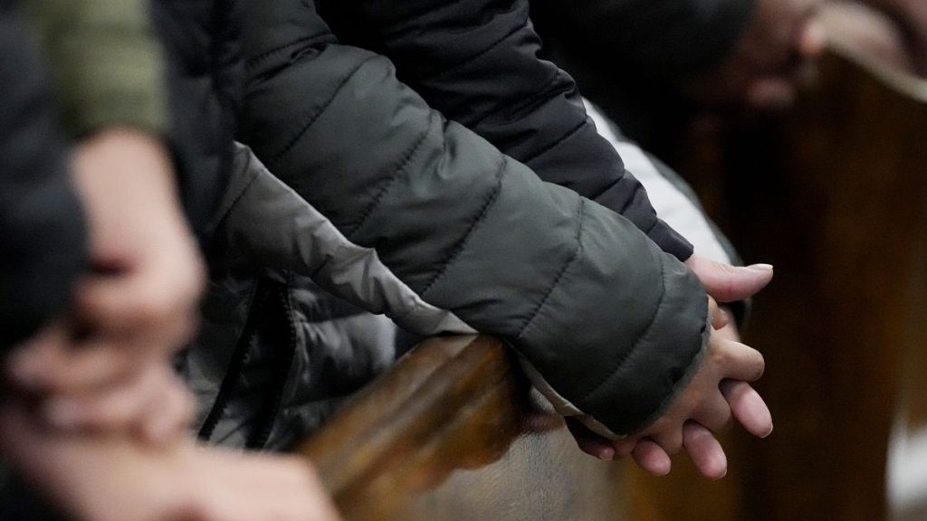 Church members hold hands together during a service at St. Rita of Cascia Parish in Chicago, Sunday