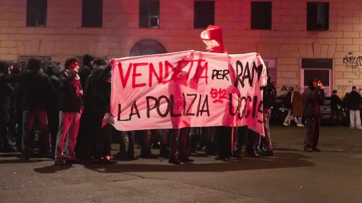 Demonstrators hold up a placard against the police in Rome