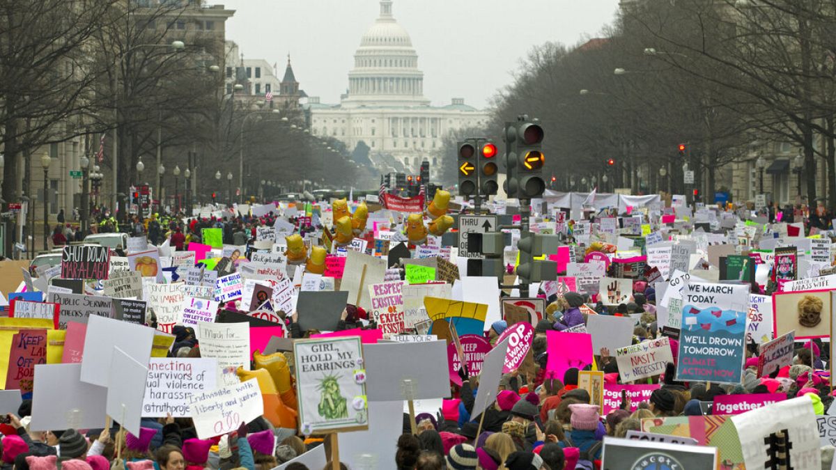 FILE - Demonstrators hold signs on Pennsylvania Avenue during the Women