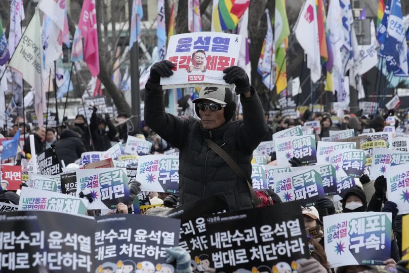 Un manifestant brandit une pancarte lors d'un rassemblement exigeant l'arrestation du président sud-coréen destitué Yoon Suk-yeol à Séoul, en Corée du Sud, le samedi 4 janvier 2025.