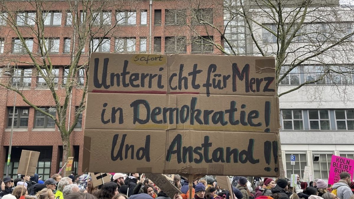 People gather to protest against the Far Right, in Cologne, Germany, Saturday Jan. 25, 2025. Banner reads: