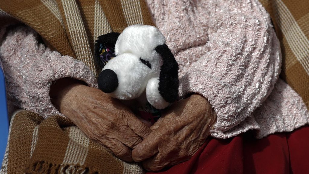 A woman holds her stuffed Snoopy dog at a home for the elderly in Bolivia in April 2021.