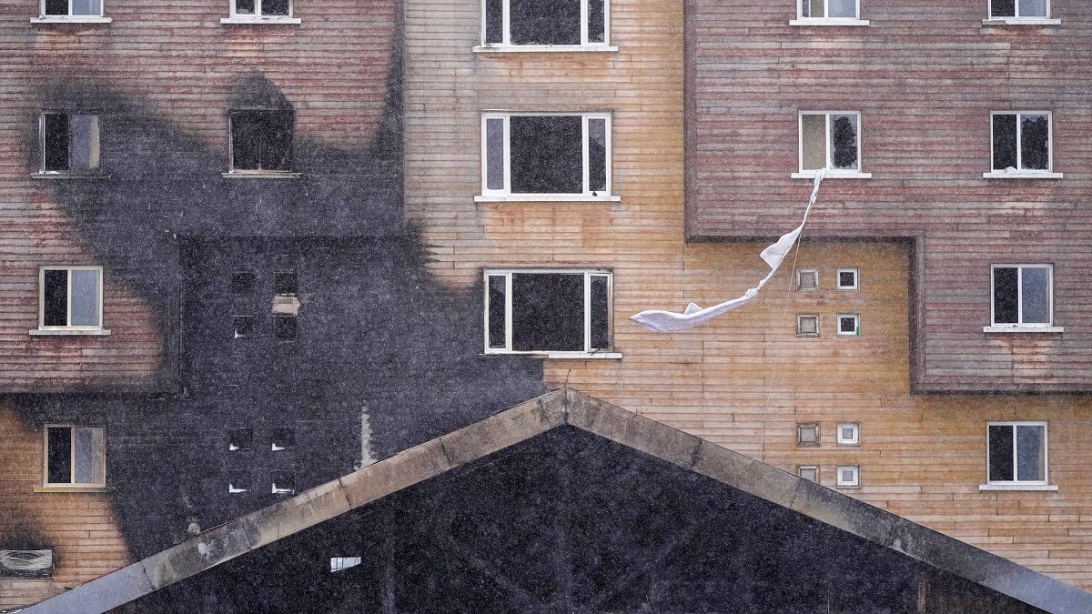 Tightened bed sheets hang from a window of a hotel where a fire broke out at the Kartalkaya ski resort in Bolu province, northwest Turkey, on Wednesday, Jan. 22, 2025.