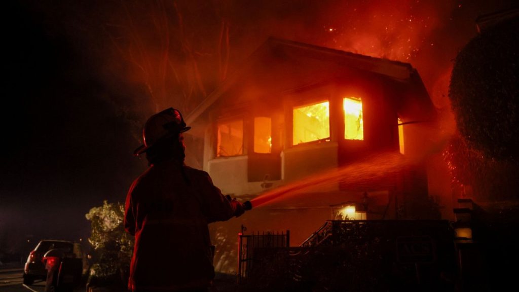 A firefighter works as the Palisades Fire burns a house in the hill next to the Getty Villa Wednesday, Jan. 8, 2025, in Pacific Palisades, Calif.