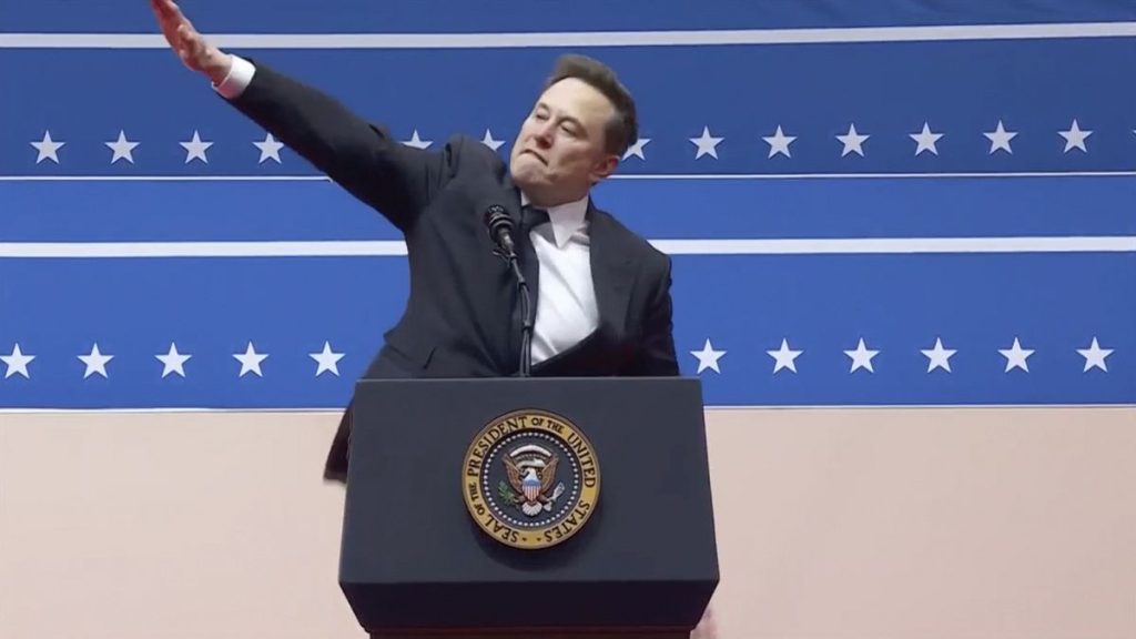 Elon Musk gestures while speaking at an indoor Presidential Inauguration parade event in Washington, Monday, Jan. 20, 2025.