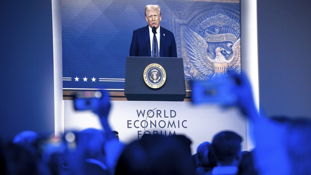 US President Donald Trump is shown on screens as he addresses via remote connection during the 55th annual meeting of the World Economic Forum (WEF), in Davos, 23 January 2025