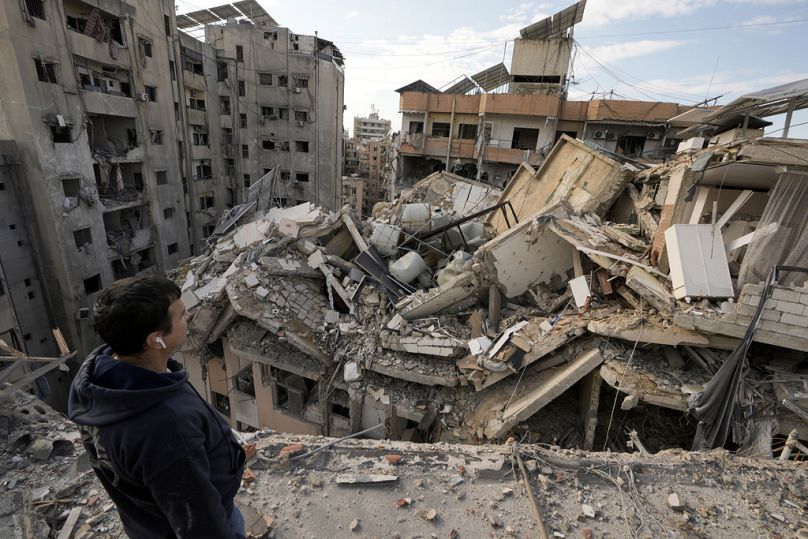 Un homme fait une pause pendant qu'il vérifie les bâtiments détruits à Dahiyeh, Beyrouth, Liban, le vendredi 29 novembre 2024.