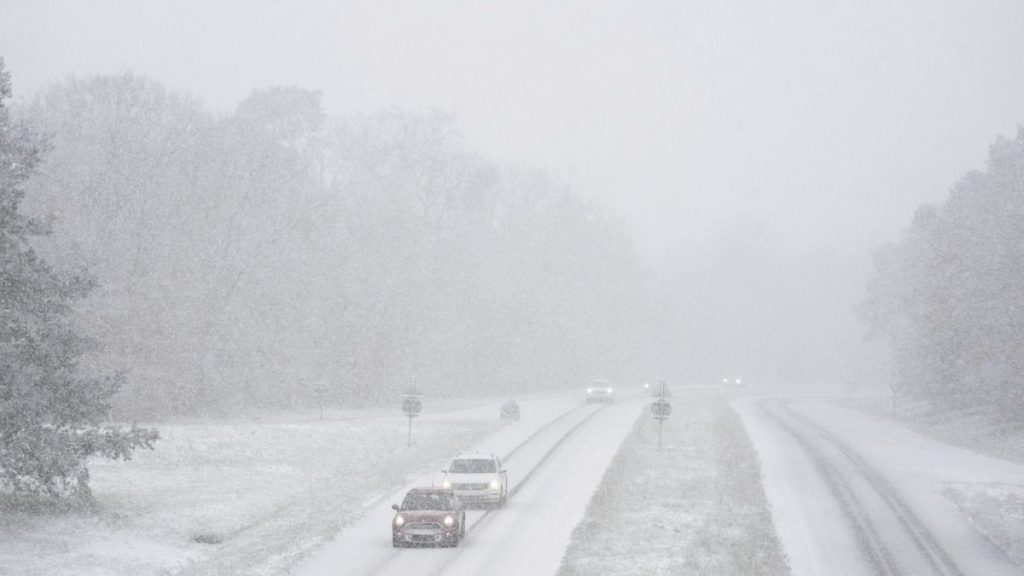 Cars drive along a snow-covered road in the forest of Fontainebleau, south of Paris, Thursday, Nov. 21, 2024