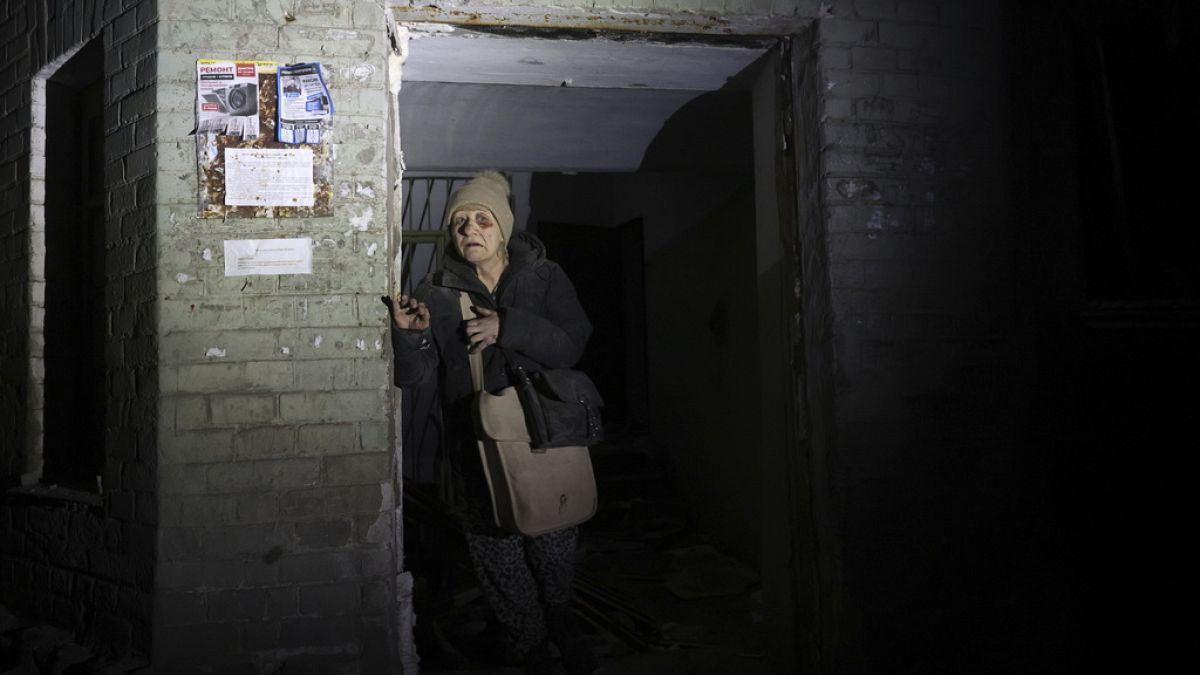 An elderly woman leaves her damaged home after missile attack in Zaporizhzhia, Ukraine, Thursday, Jan. 23, 2025.