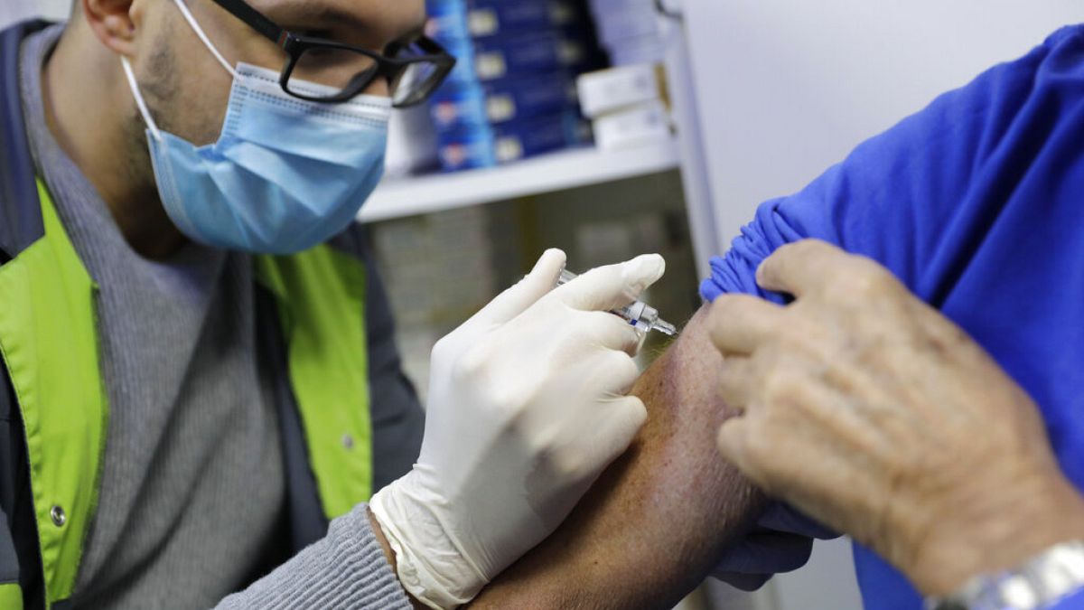 A pharmacist administers a flu vaccine in a Paris drugstore in October 2020.