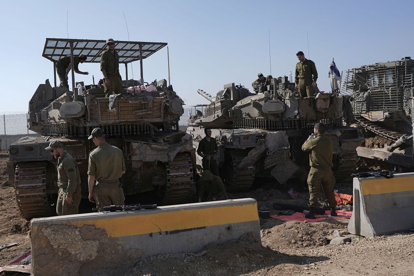 Des soldats israéliens travaillent dans une zone de transit à la frontière entre Israël et Gaza après leur retour de la bande de Gaza, le 18 janvier 2025.