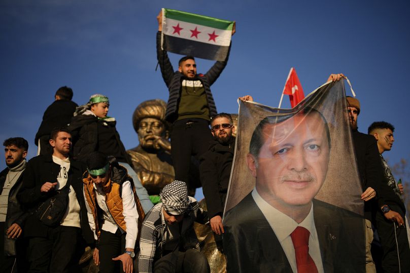 Des gens brandissent une banderole du président turc Recep Tayyip Erdogan alors qu'ils célèbrent la chute du gouvernement syrien à Istanbul, en Turquie, le dimanche 8 décembre 2024. (AP Photo/Emra