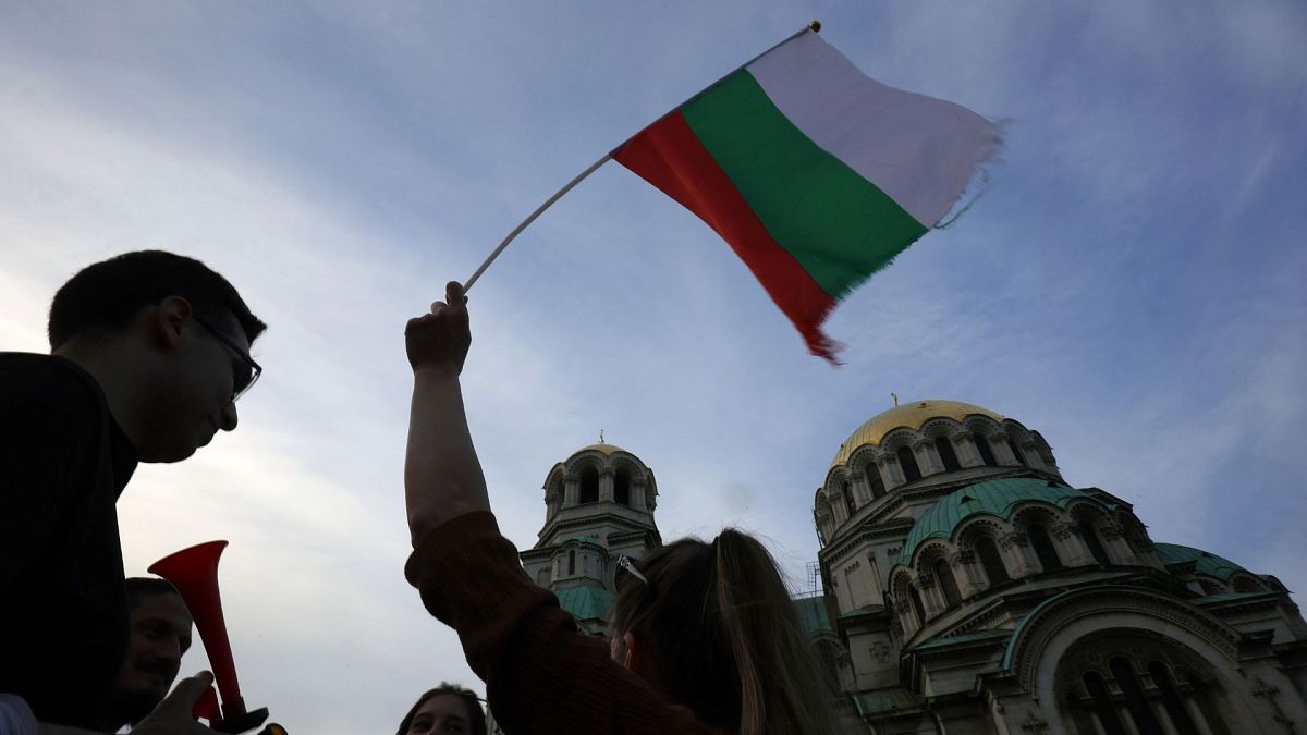 FILE - A pro-government protester holds a Bulgarian flag during a demonstration in support of incumbent Bulgarian government, 21 June 2022.