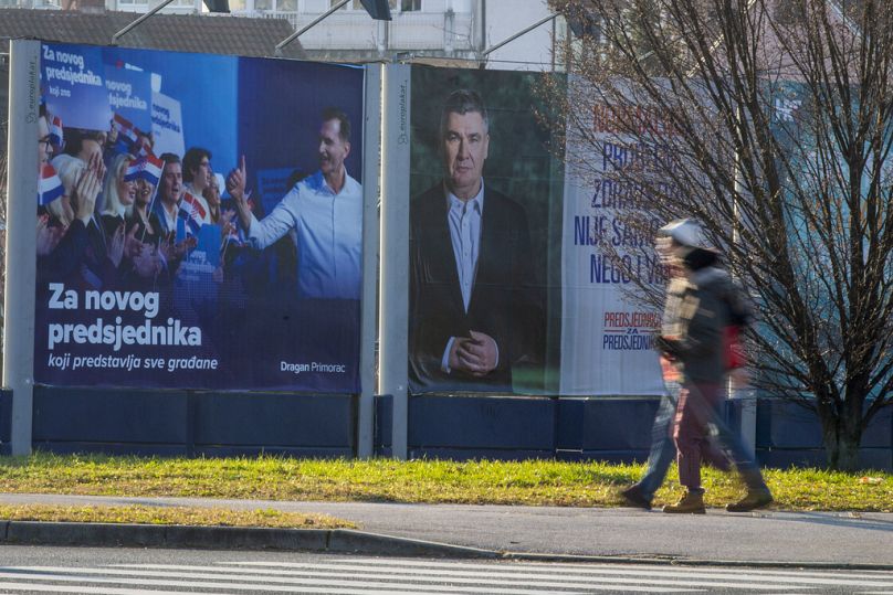 Des piétons passent devant les affiches de campagne des candidats à la présidentielle Dragan Primorac et Zoran Milanovic avant l'élection présidentielle à Zagreb, en Croatie, le jeudi 26 décembre.