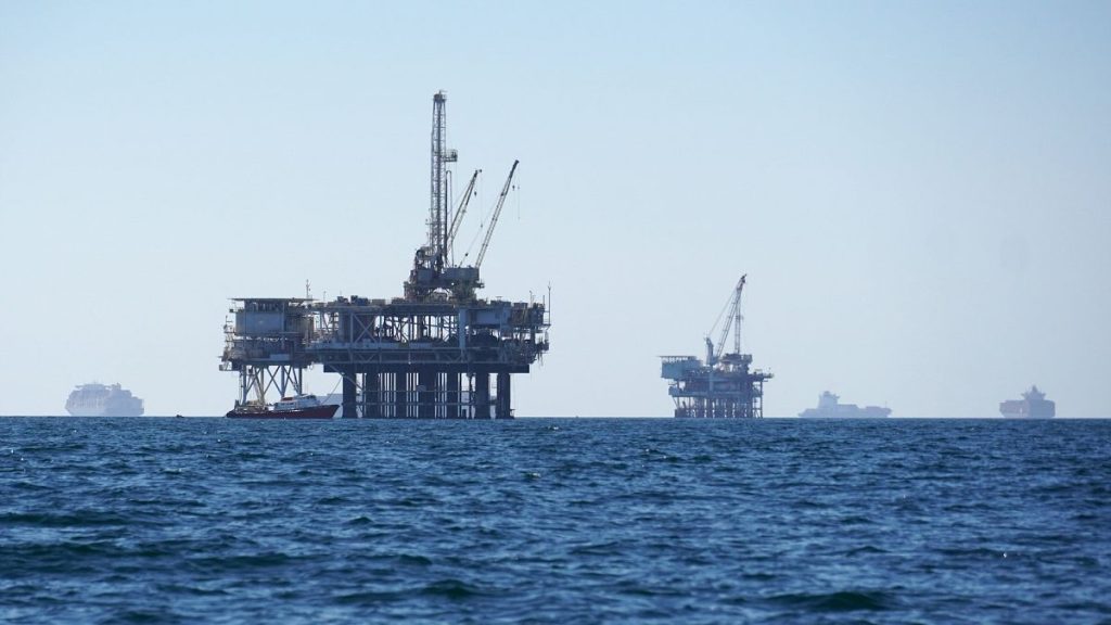 File picture of cargo vessels anchored offshore, sharing space with oil platforms, before heading into the Los Angeles-Long Beach port in the US