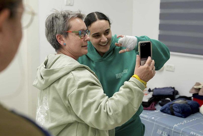 Emily Damari, à droite, et sa mère Mandy utilisent un téléphone intelligent près du kibboutz Reim, dans le sud d'Israël, après qu'Emily ait été libérée de captivité par le Hamas