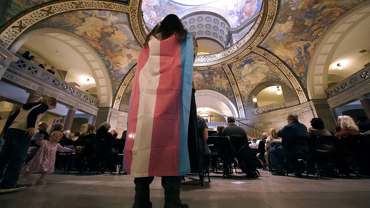 A young person wears a transgender flag in March 2023 at a political event in Missouri, United States.