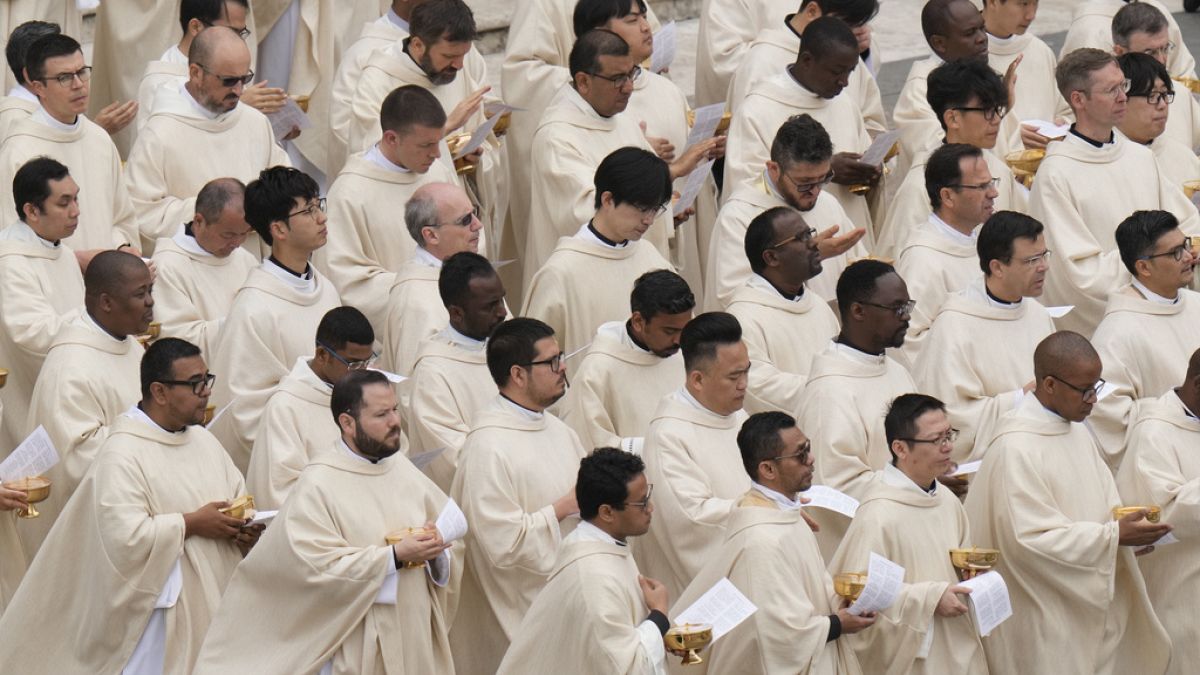 FILE - Priests stand during Easter mass in St. Peter