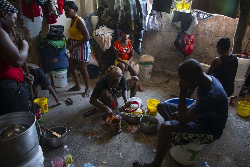 Une femme prépare à manger dans un refuge pour familles en Haïti.