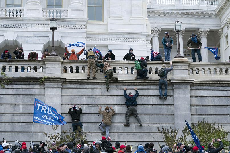 Les partisans du président Donald Trump escaladent le mur ouest du Capitole américain à Washington, le 6 janvier 2021.