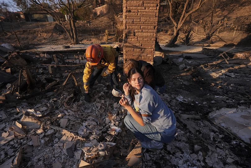 Une femme fouille les décombres de sa maison avec le capitaine du service d'incendie de Glendale, Chris Jernegan, le 11 janvier 2025.