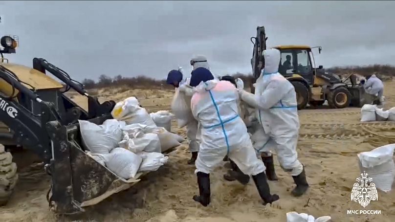 Des ouvriers nettoient des tonnes de fioul déversées par deux pétroliers frappés par la tempête il y a plus de deux semaines dans le détroit de Kertch, le 4 janvier 2024.