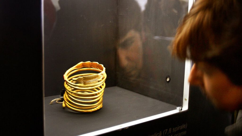 FILE - A woman takes a close look at an ancient Dacian gold bracelet on display at the National History museum in Bucharest Romania Monday Jan. 22 2007