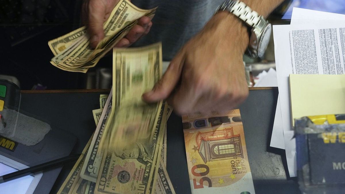 File picture: A cashier changes a 50 Euro banknote with US dollars at an Italian exchange bureau