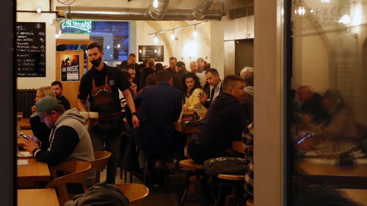 FILE - A waitor carries beers at a pub downtown Prague, Czech Republic, Tuesday, Oct. 13, 2020.