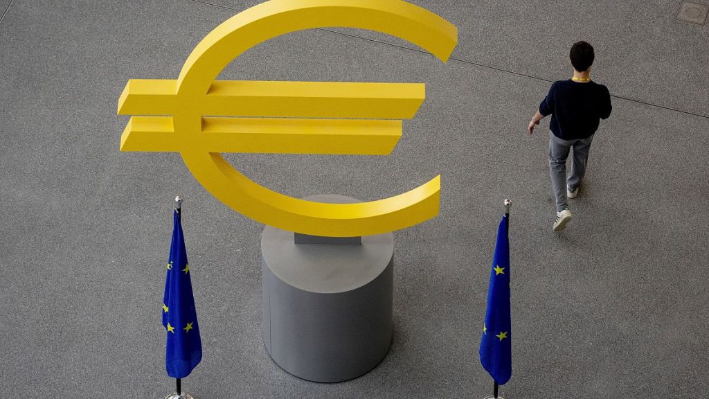 A man walks past a Euro sign in the hallway of the European Central Bank after a meeting of the ECB