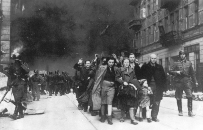   Sur cette photo d'archive de 1943, un groupe de Juifs polonais est emmené en vue d'être déporté par des soldats SS allemands lors de la destruction du ghetto de Varsovie par les troupes allemandes.