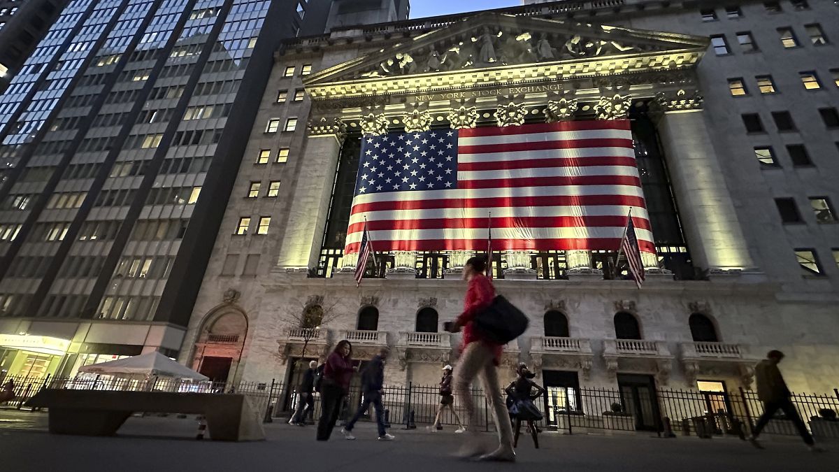 People pass the New York Stock Exchange in New York.