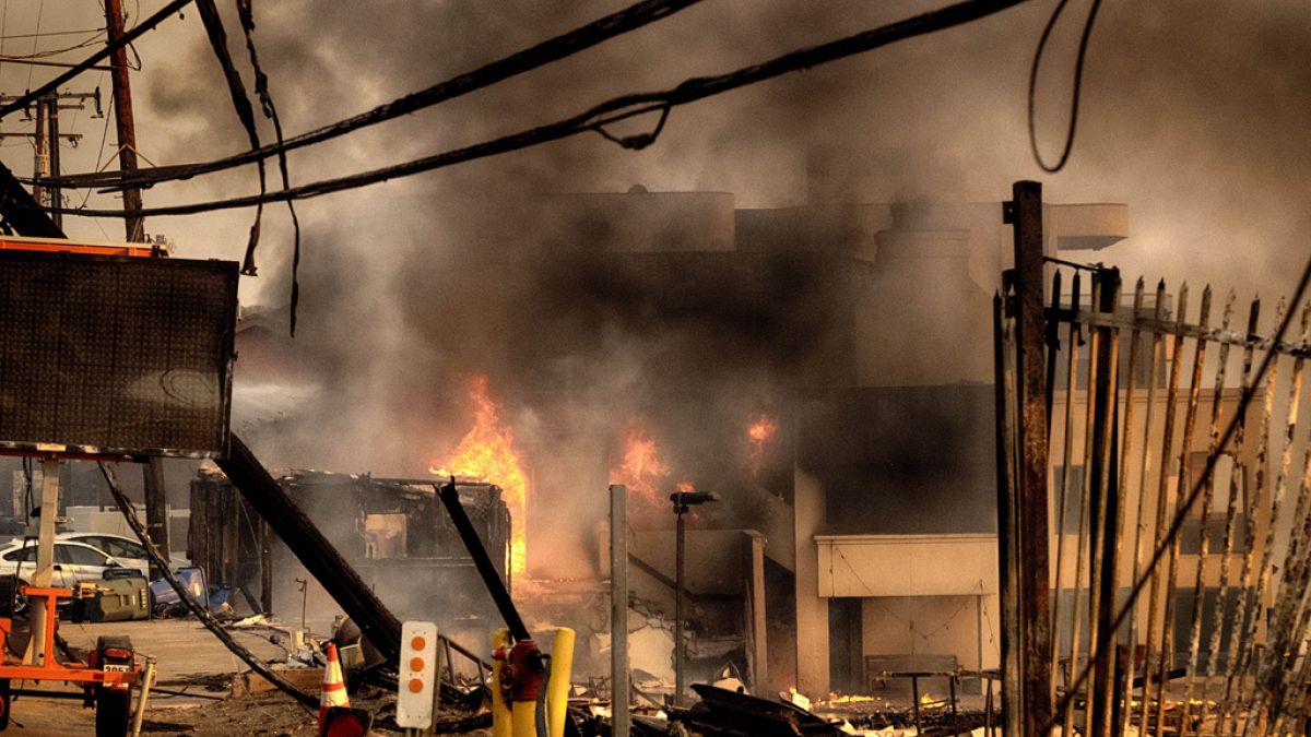 Firefighters douse a burning home along the beach in Malibu, Calif. on Wednesday, Jan. 8, 2025.