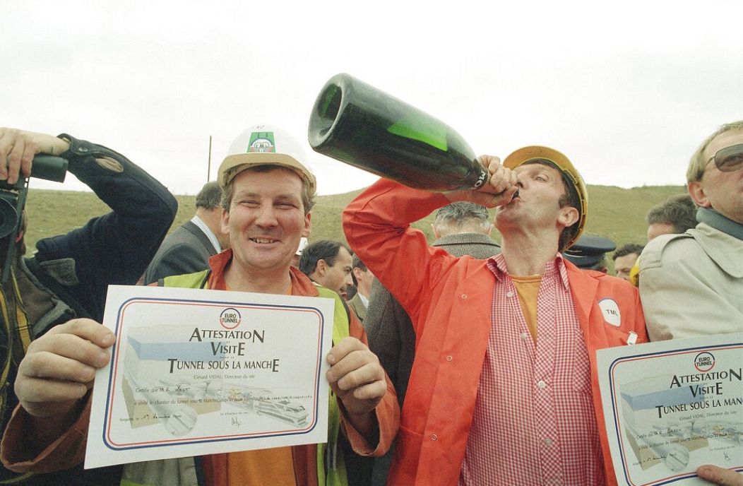 Le principal mineur Roy West présente son certificat de visiteur tandis que le chef d'équipe Ray Green boit du champagne pour célébrer la percée du tunnel sous la Manche - Sangette, France. décembre 1990