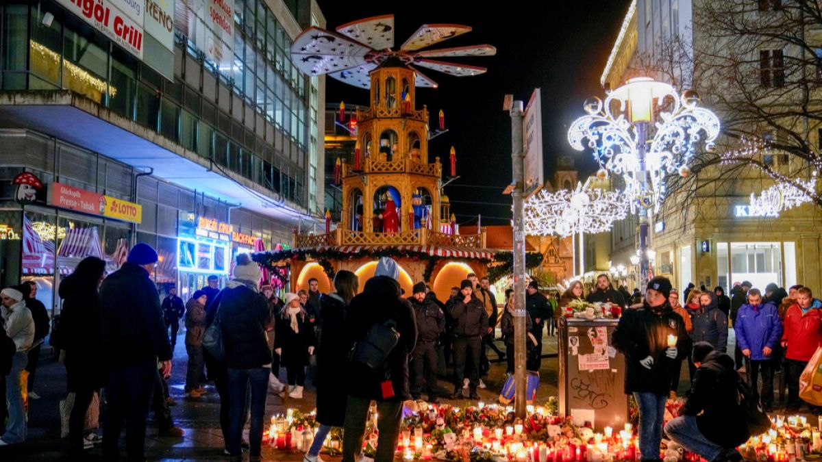 People attend an AfD election campaign in near the Christmas Market in Magdeburg, Germany, Monday, Dec. 23, 2024.