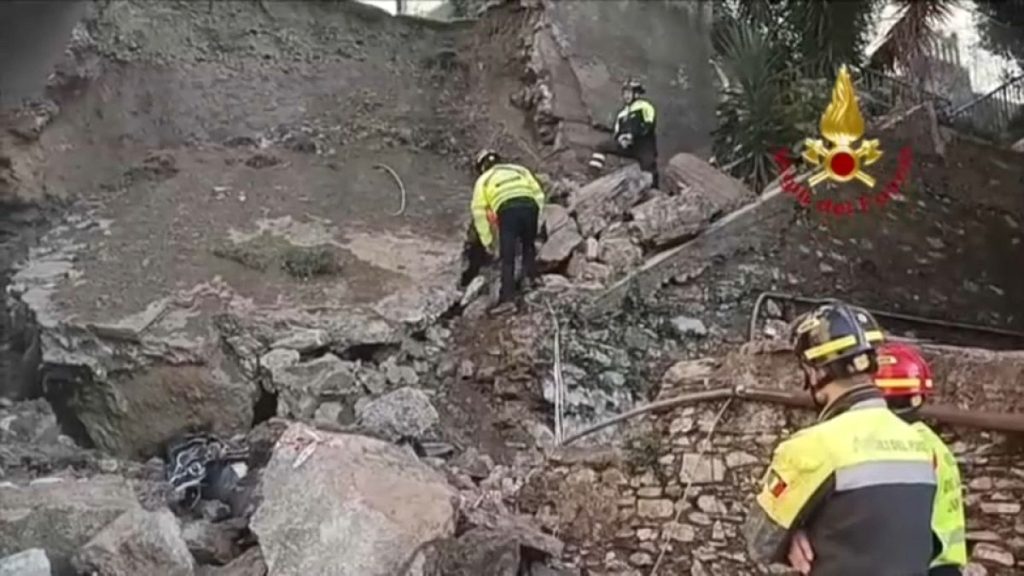 Italian firefighters search through the rubble of a collapsed wall in Genoa, Italy.