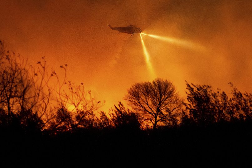 Un hélicoptère largue de l'eau alors qu'il combat un incendie automobile dans le comté de Ventura, en Californie - lundi 13 janvier 2025