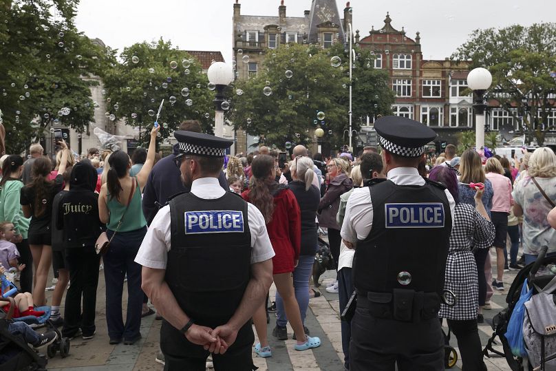 Des policiers observent des membres du public devant l'hôtel de ville de Southport, en Angleterre, le 5 août 2024.