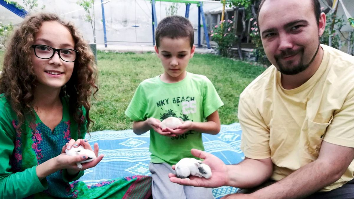 This family photo shows Ryan Corbett holding rabbits with his daughter Miriam and son Caleb in Kabul, Afghanistan in 2020.