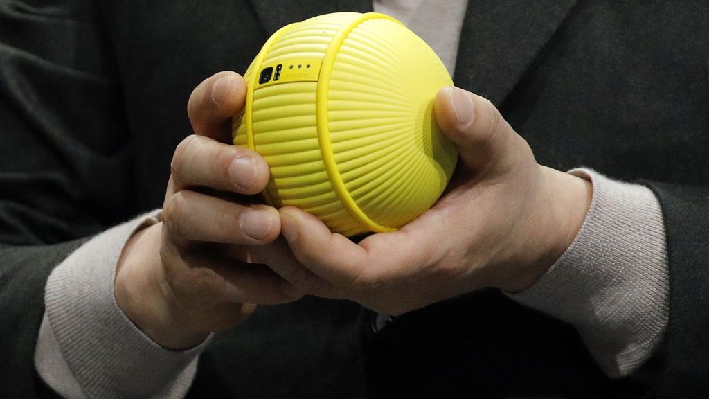 Hyun-Suk Kim, president and CEO of the Consumer Electronics Division at Samsung, holds Ballie, an AI rolling robot during a Samsung keynote before the CES tech show, 2020.