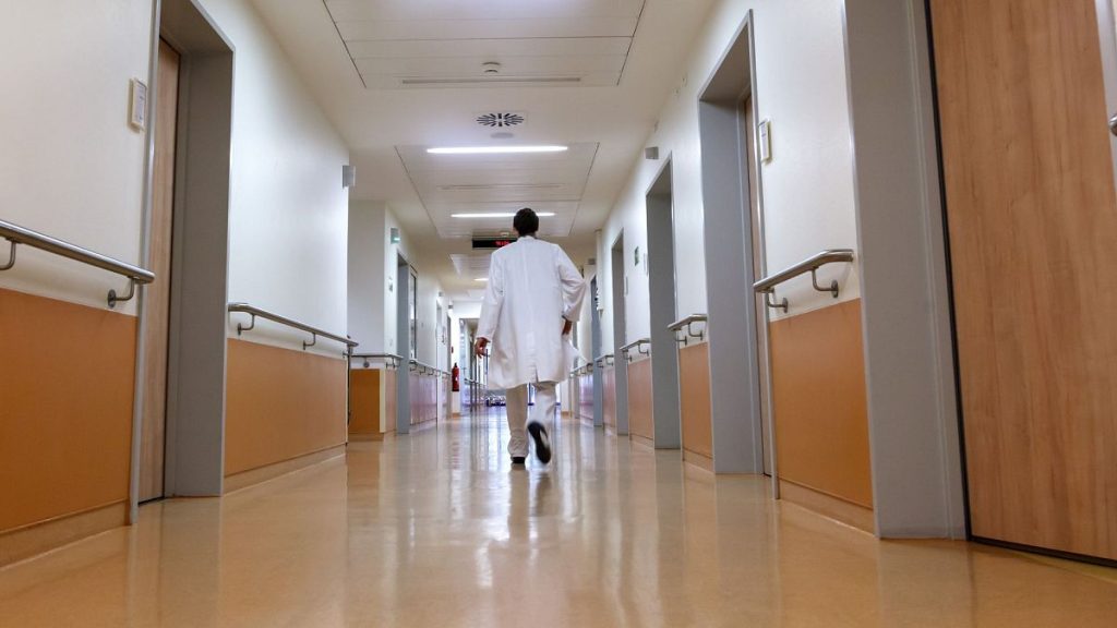 A doctor walks down the hallway.