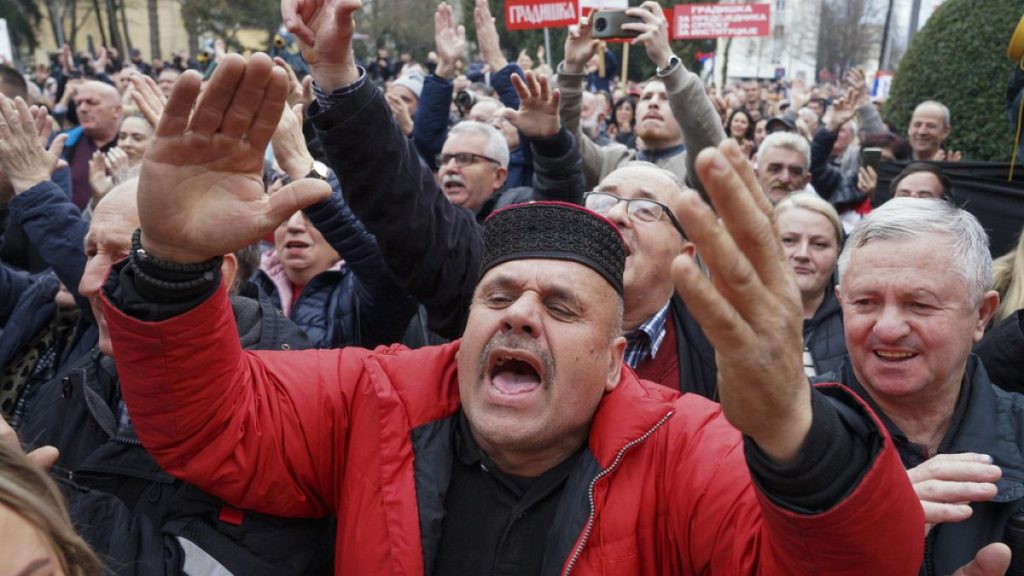 Supporters of Bosnian Serb President Milorad react after a court sentenced him to one year in prison