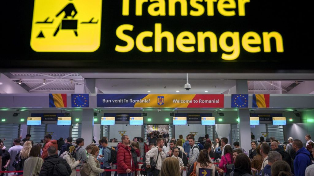 Passengers arriving at Henri Coanda international airport pass under a Schengen information board in Otopeni, near Bucharest, Romania, on 31 March 2024.