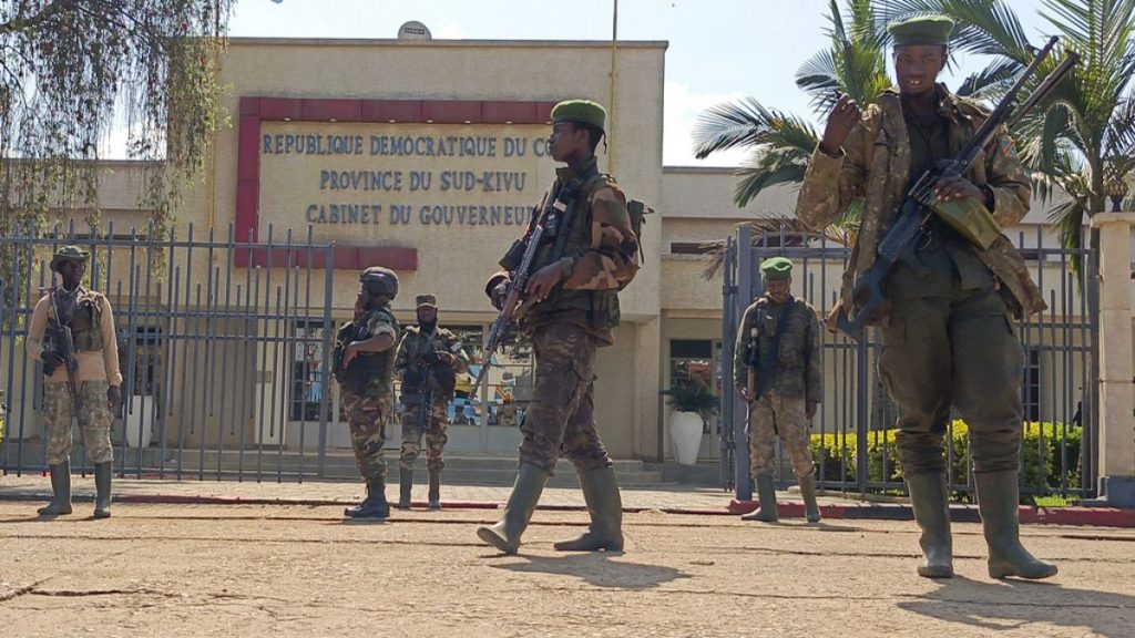 M23 rebels guard outside the South Kivu province administrative office, at the centre of east Congo